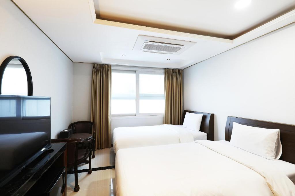 a hotel room with two beds and a desk at Intercity Seoul Hotel in Seoul