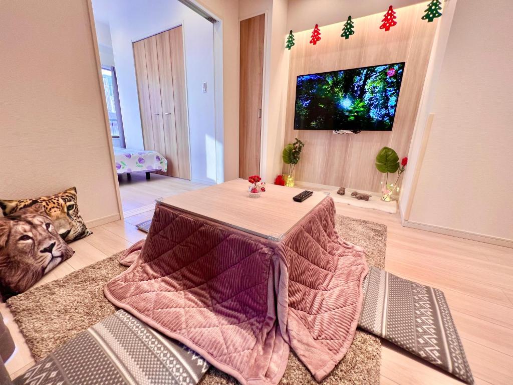 a living room with a table and a television at Tokyo Shinjuku INN in Tokyo