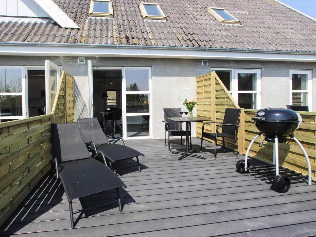 een barbecue op een terras met stoelen en een grill bij 2 person holiday home in Nex in Neksø