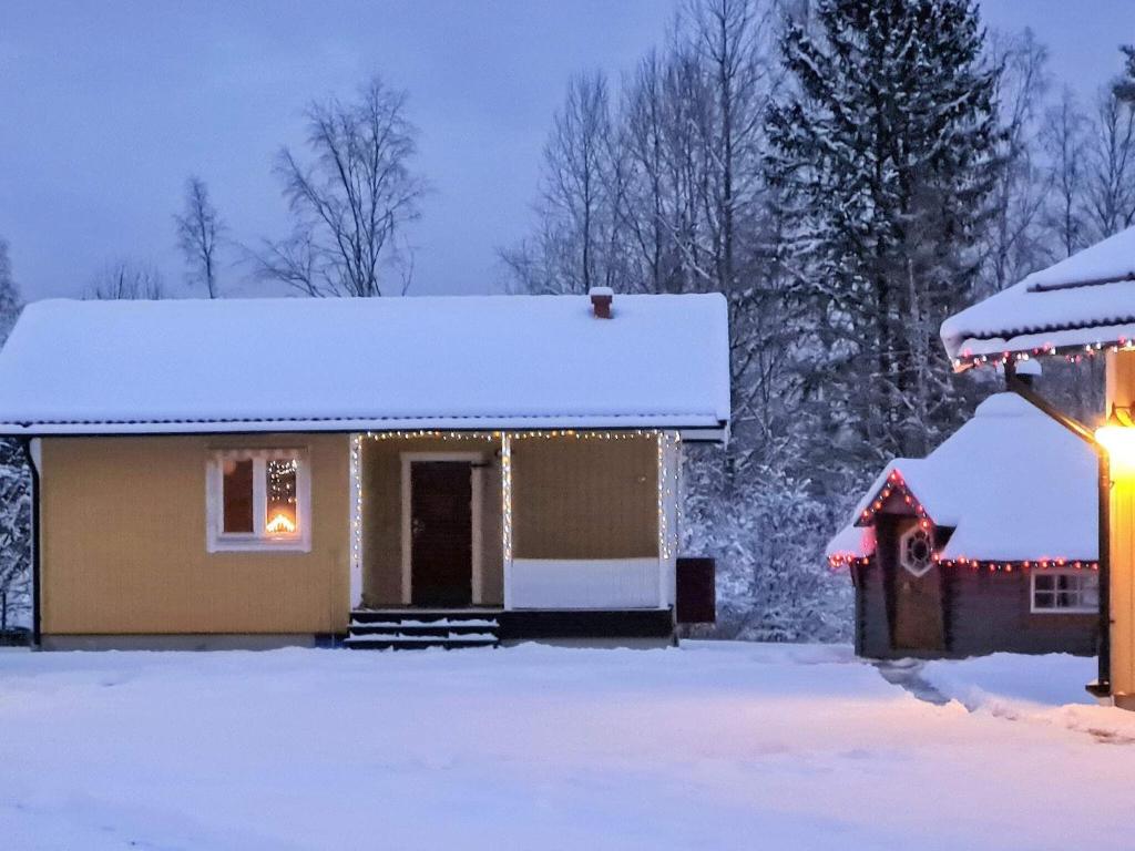 una casa cubierta de nieve con una luz de Navidad en 4 person holiday home in LJUSDAL, en Ljusdal