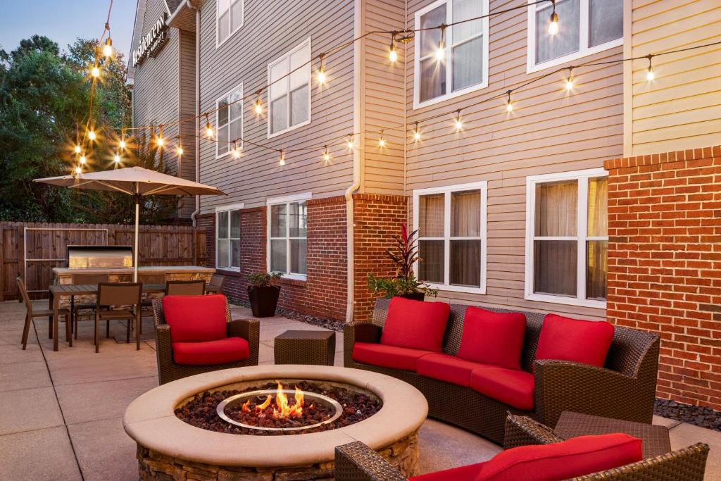 a patio with chairs and a fire pit in front of a building at Residence Inn Mobile in Mobile