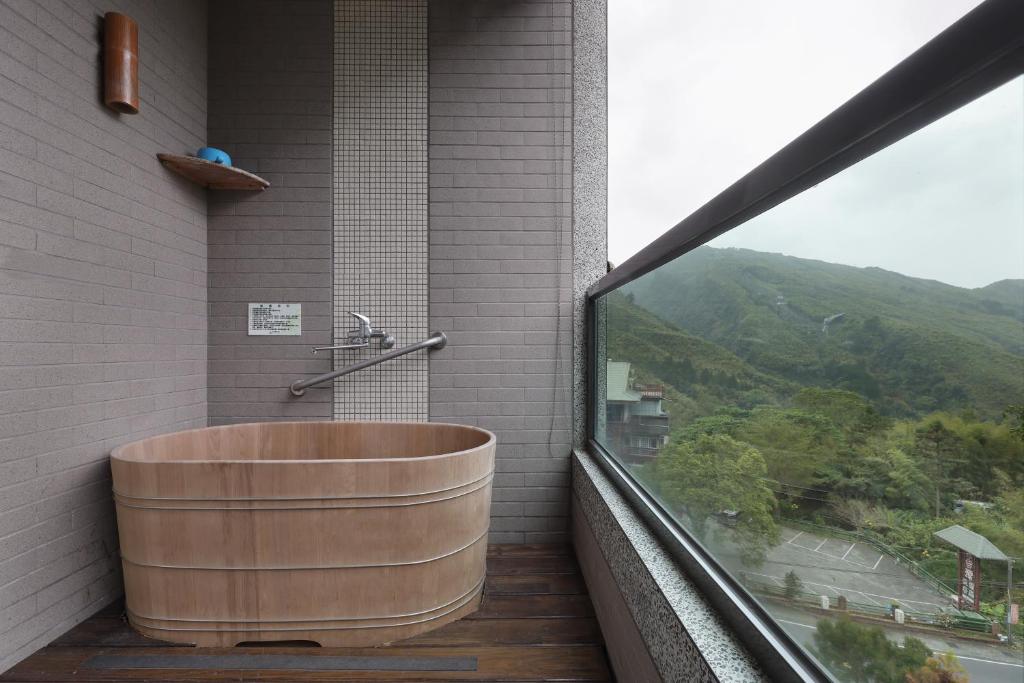 a bath tub on a balcony with a view at Shante Hotel Shitou in Lugu Lake