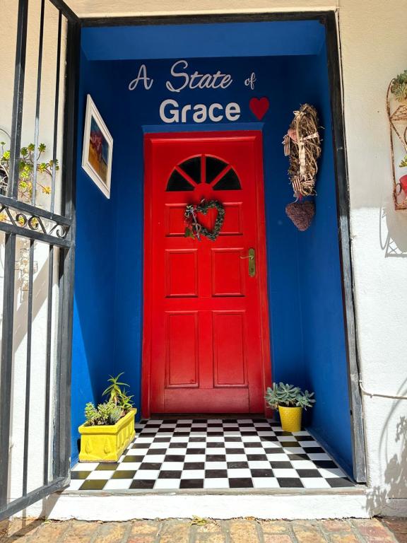 una porta rossa con le parole uno stato di garage di A State of Grace a Clanwilliam