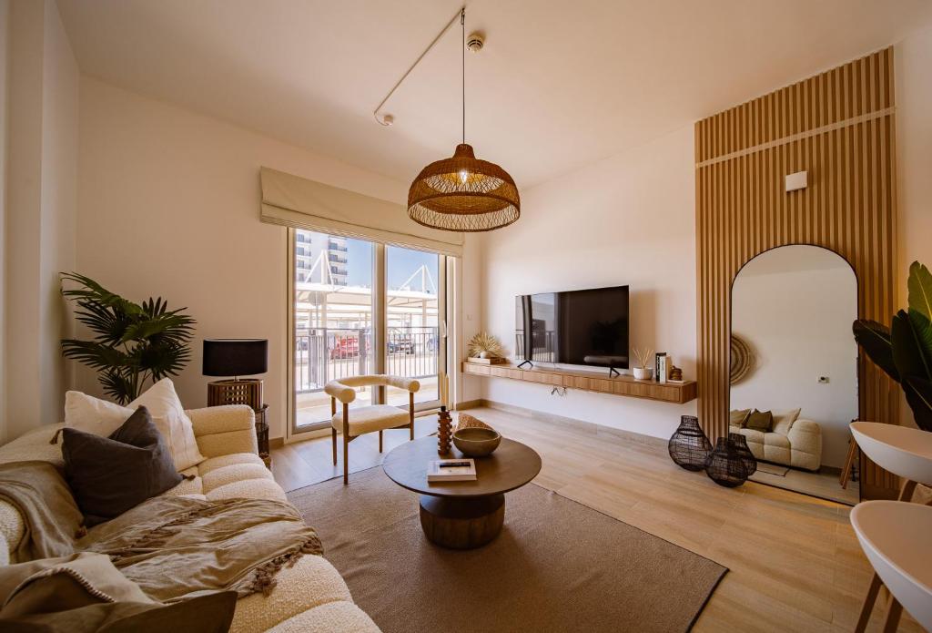 - un salon avec un canapé et une table dans l'établissement One Bedroom Apartment By Voyage, à Abu Dhabi