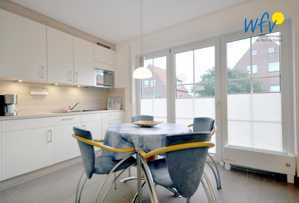 a kitchen with a table with blue chairs in it at Juist Zauber - Haus 2 Ferienwohnung Jansen in Juist