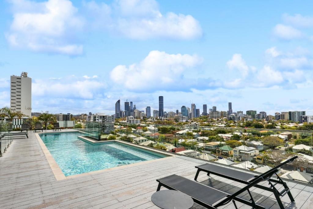 a swimming pool on the roof of a building with a city at Sleek 1-Bed With Rooftop Pool & Amazing City Views in Brisbane