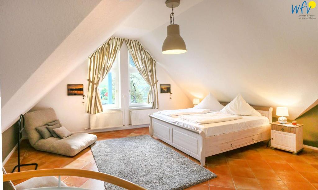 ein Schlafzimmer mit einem Bett, einem Stuhl und einem Fenster in der Unterkunft Ferienpark Seedorf Fischerhaus - Ferienwohnung 12 in Sellin