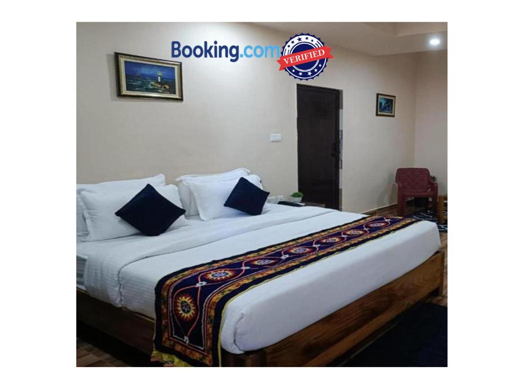 Cette chambre comprend un grand lit avec des oreillers bleus. dans l'établissement Goroomgo Silicon Residency Puri Near Sea Beach - Parking & Lift Facilities - Best Hotel in Puri, à Purî