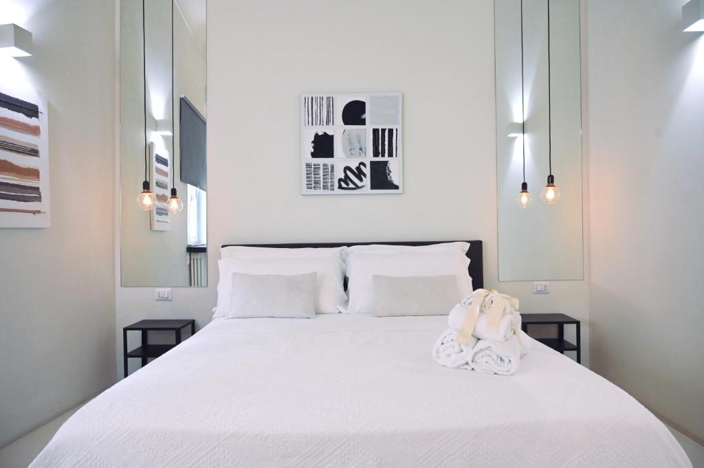 a bedroom with a white bed with a stuffed animal on it at 42 Zanardelli B&B in Trani