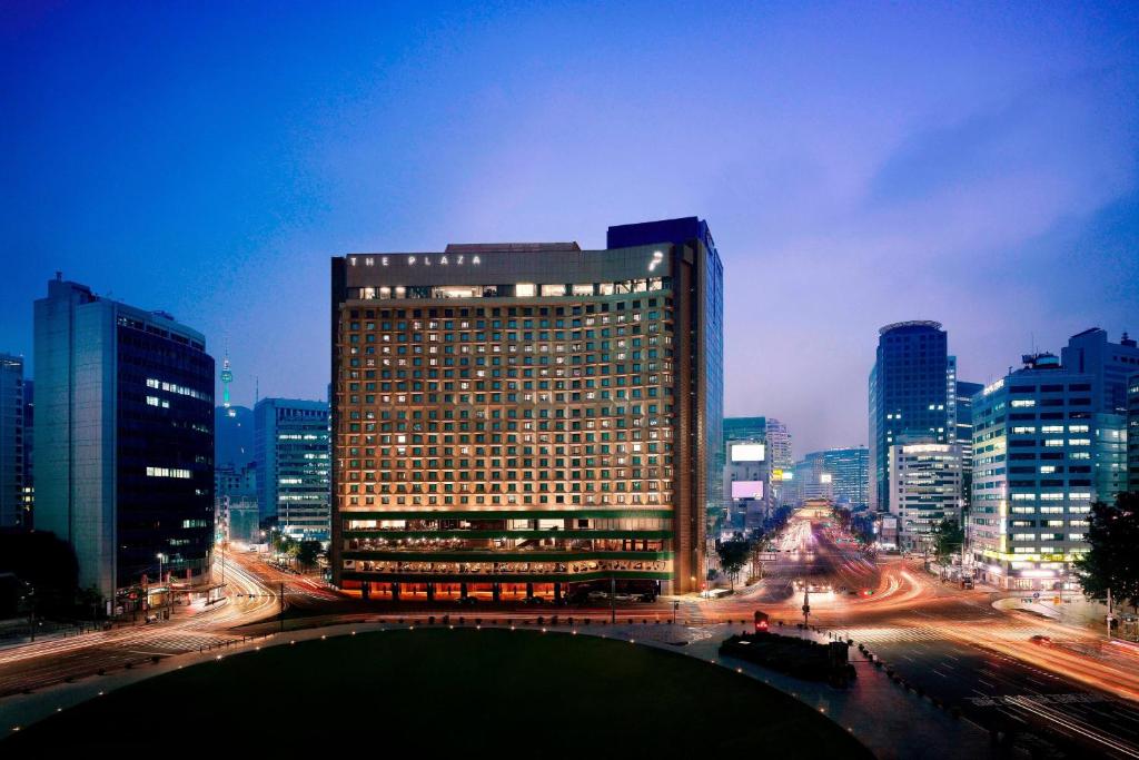 a large building in the middle of a city at night at THE PLAZA Seoul, Autograph Collection in Seoul