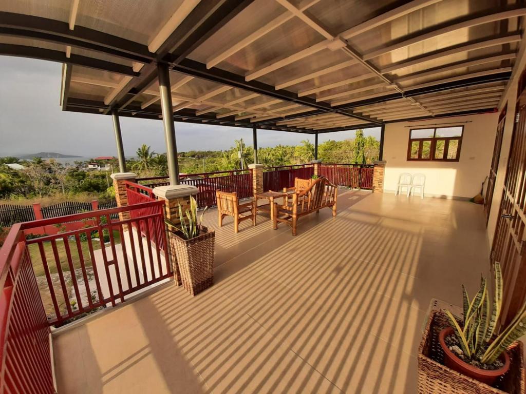 a patio with a roof with a table and chairs at Michael's Apartment in Moalboal