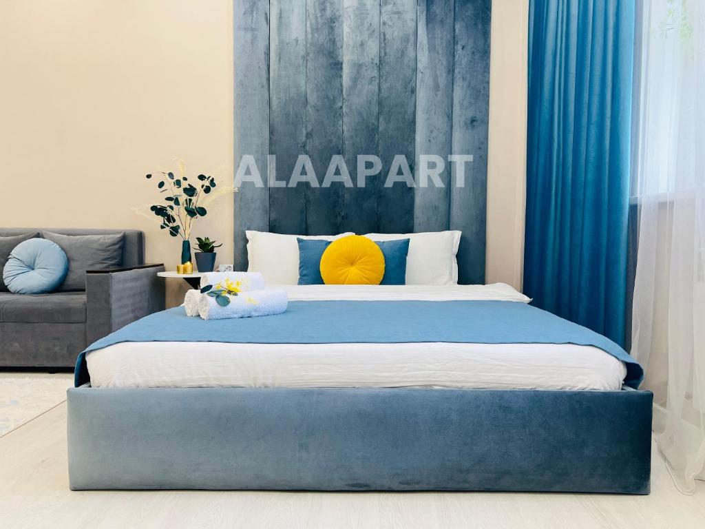 a bedroom with a large bed with a blue headboard at 396I1 Blue Horizon Apartments Sholpan city in Almaty