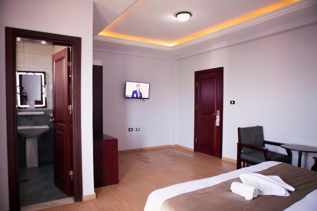 een slaapkamer met een bed, een wastafel en een spiegel bij Filagot Hotel in Adama