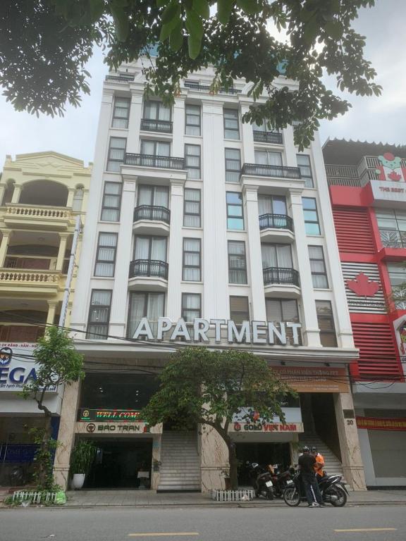 a large white building with a sign on it at BaoTran Apartment & hotel in Ðông Khê