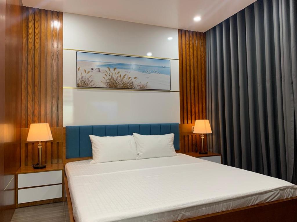 1 dormitorio con 1 cama grande y 2 lámparas en BaoTran Apartment & hotel, en Ðông Khê