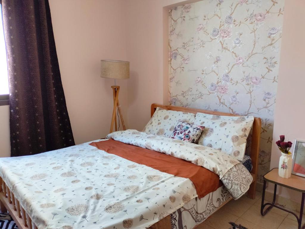 a bedroom with a bed with a floral wallpaper at Cozy apartment Maadi Ring road in Cairo