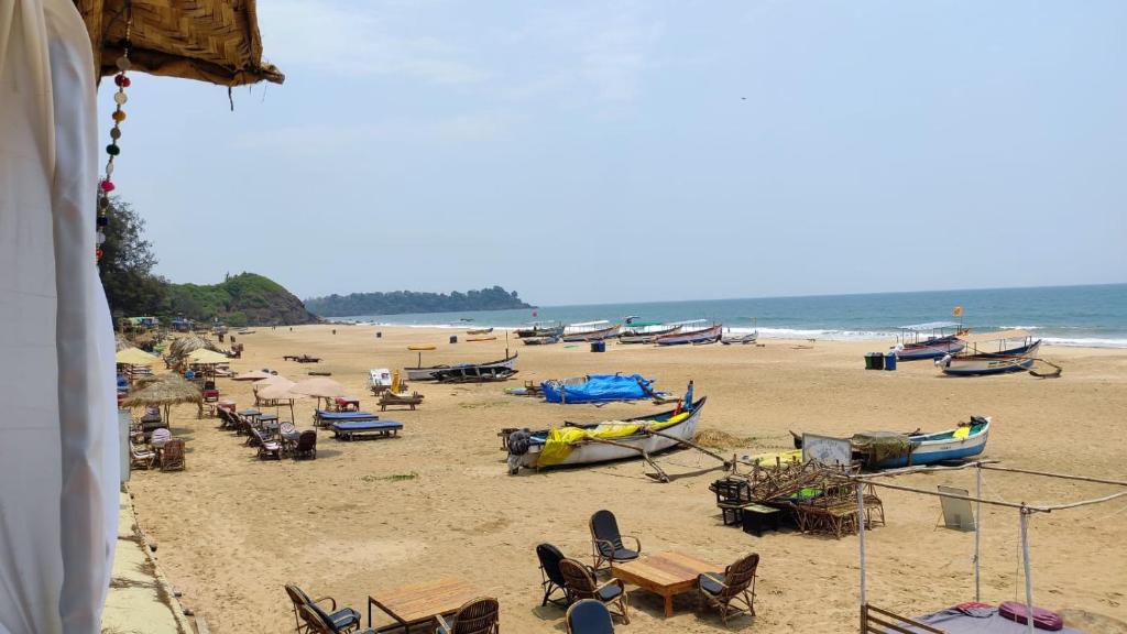 a beach with a bunch of chairs and boats on it at Royal cottage in Palolem