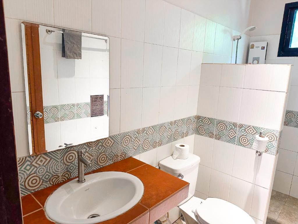a bathroom with a sink and a toilet at Jungle Vibes in Thongsala