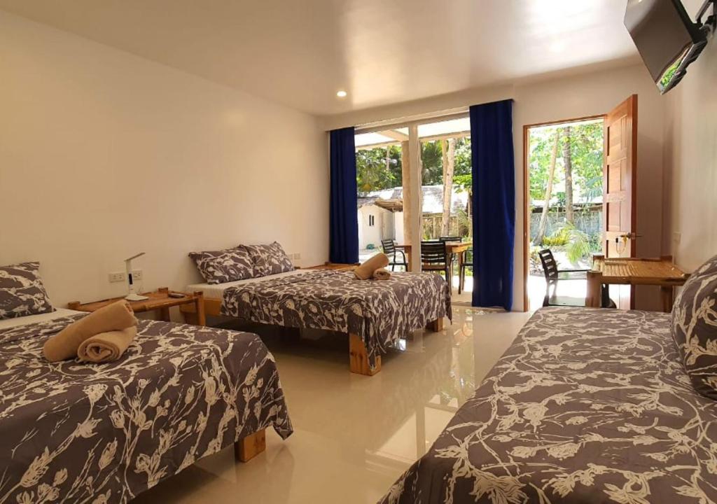 Habitación con 3 camas y sala de estar. en Pili Beach Resort Agmanic en Santa Fe