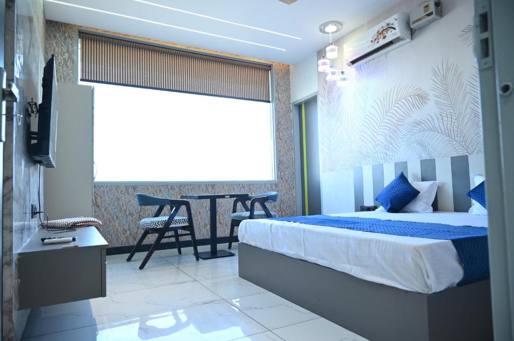 um quarto com uma cama, uma mesa e uma televisão em Hotel Lions lounge em Hisār