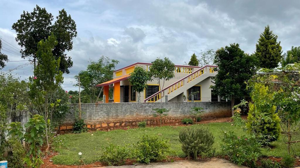 Jupiter villa في ييلاجيري: منزل في ساحة مع أشجار واعشاب