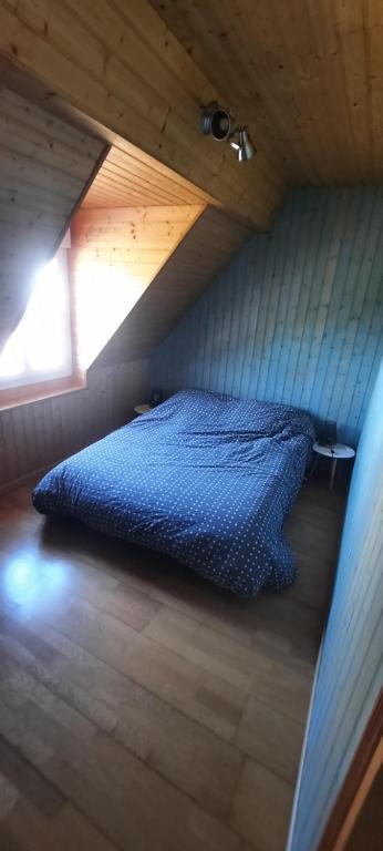 - une chambre mansardée avec un lit bleu dans l'établissement location ault, à Ault