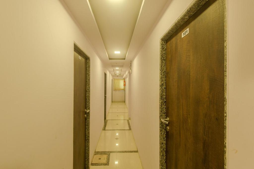 a corridor with a door and a hallway with stairs at OYO Hotel Stayland Near Juhu Beach in Mumbai