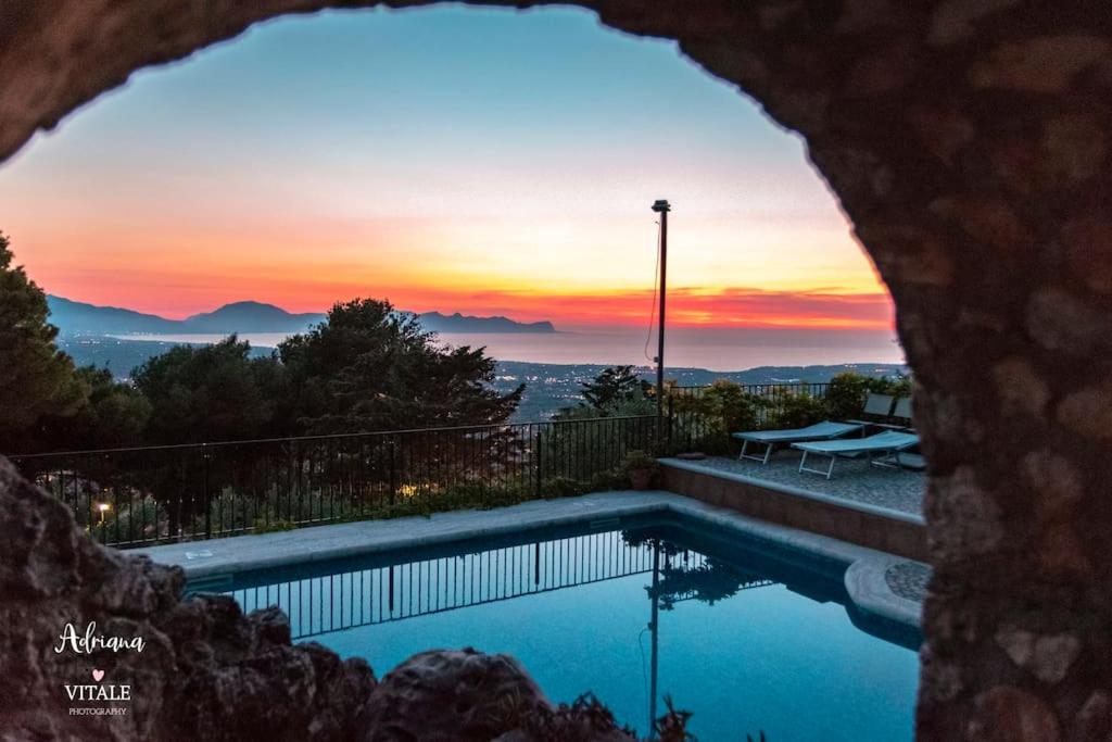 a swimming pool with a sunset in the background at Holiday house Sicily in Borgetto