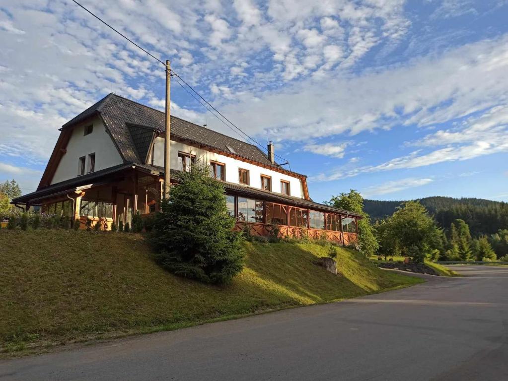 a house on the side of a hill with a street at Penzion U Vody in Horní Bečva