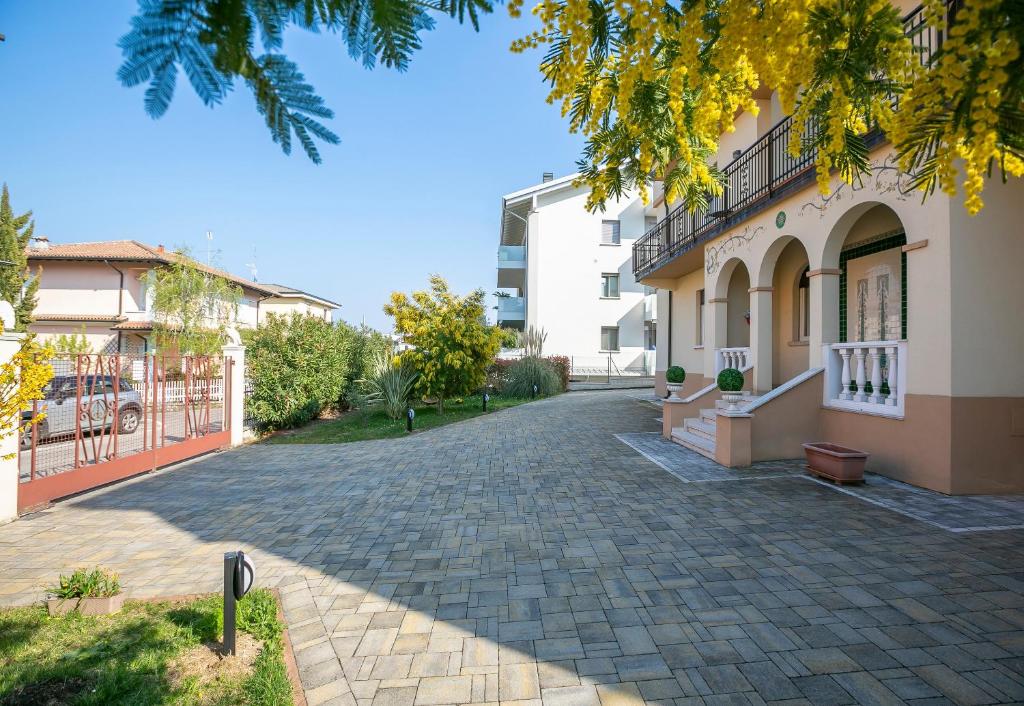 una entrada de adoquines frente a un edificio en Villa Mimosa - Appartamento 1 - Happy Rentals, en Desenzano del Garda