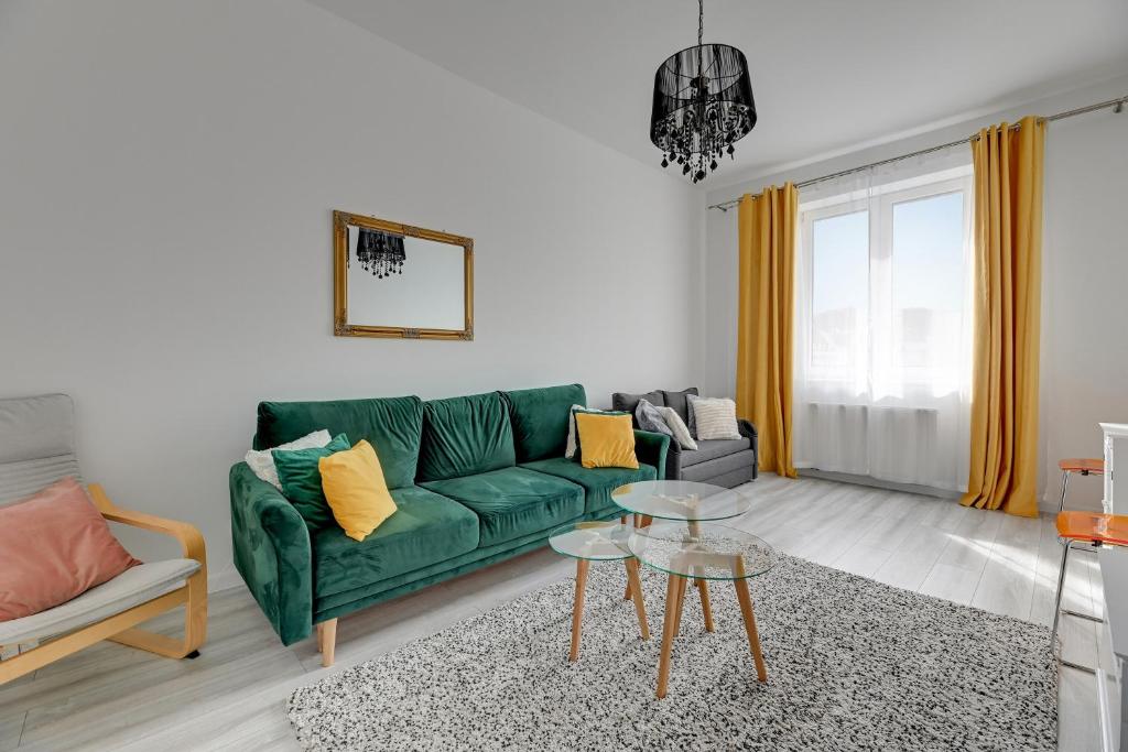 格但斯克的住宿－Primavera by Grand Apartments，客厅配有绿色沙发和桌子
