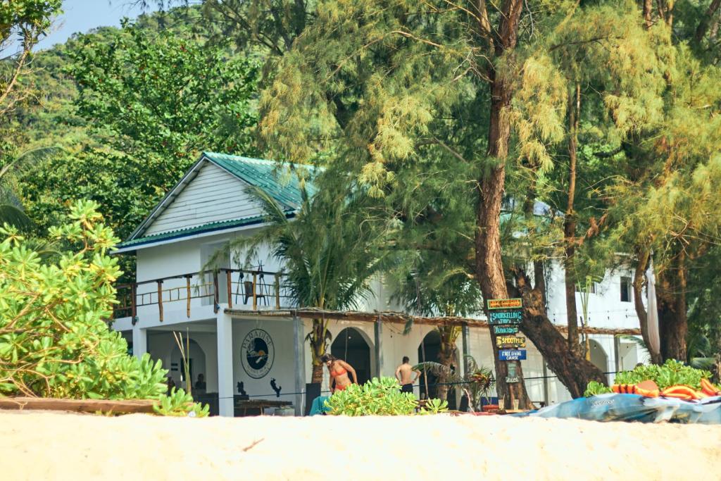 una casa sulla spiaggia accanto a un albero di Paradise Sunset Beach a Koh Rong Sanloem