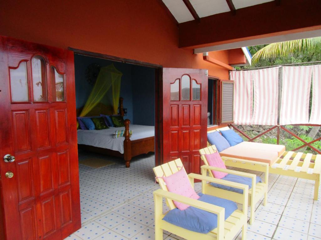 a room with red doors and chairs and a bedroom at The Sweet Retreat in Port Elizabeth