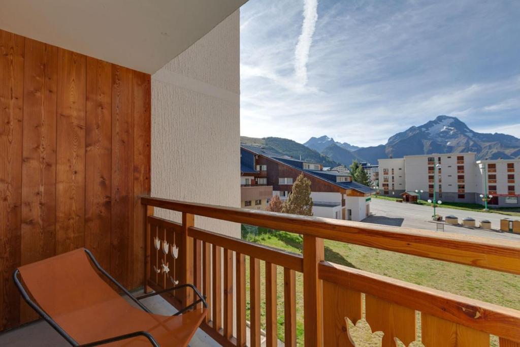 une chaise sur un balcon avec vue sur les montagnes dans l'établissement Cabourg - 19 - Studio proche pistes - 4 pers, à Les Deux Alpes