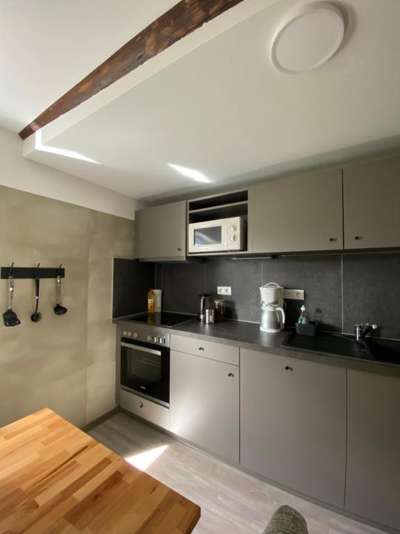 a kitchen with stainless steel appliances and a wooden table at PHOENIX Apartments - Monteurwohnung mit RIESIGER Parkfläche in Bielefeld
