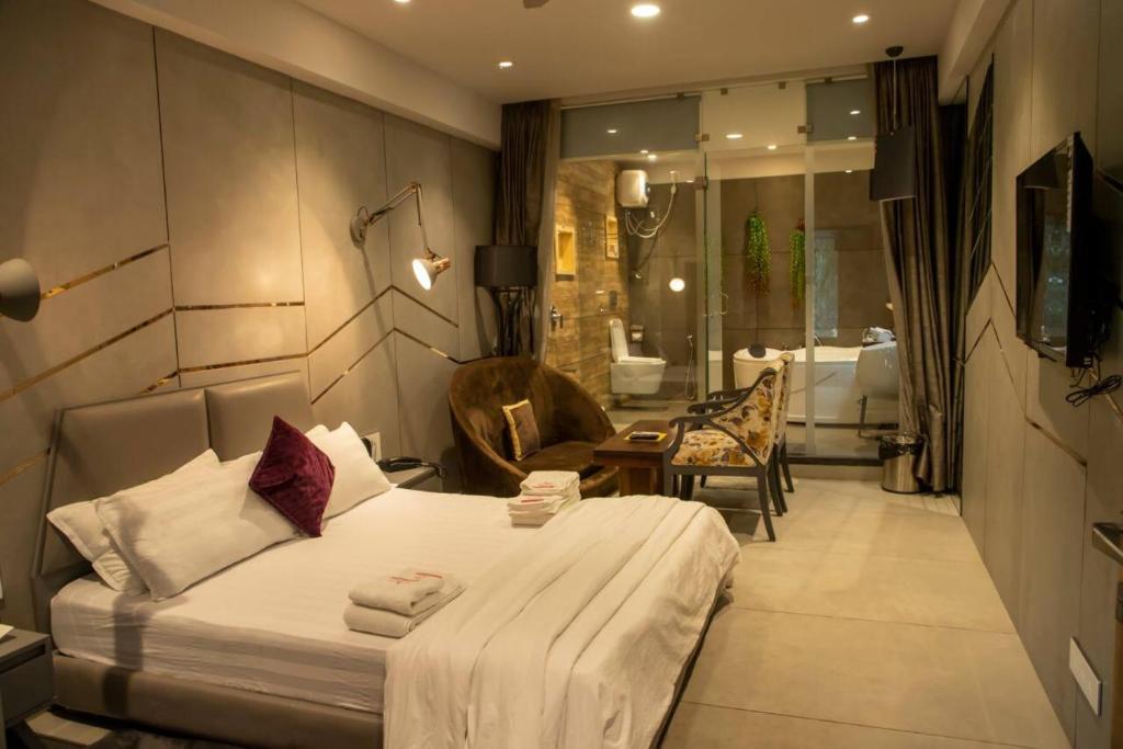 ein Hotelzimmer mit einem Bett und einem Bad in der Unterkunft HOTEL WELCOME in Surat