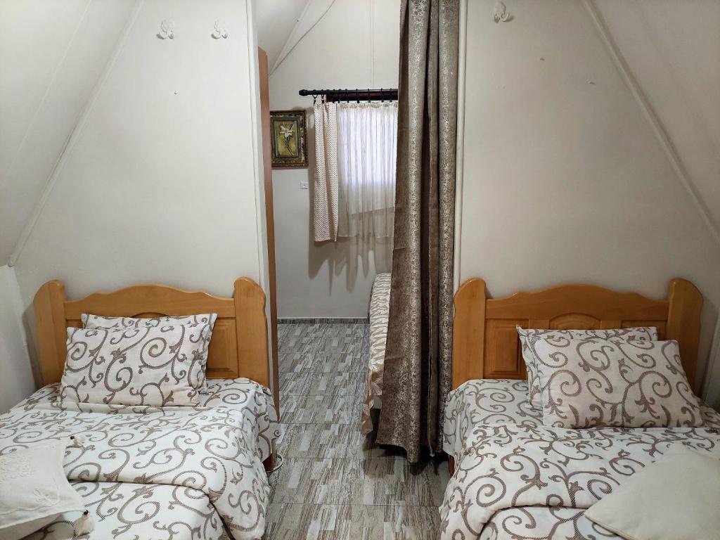 a bedroom with two beds and a mirror at Vikendica Drinski mir in Loznica