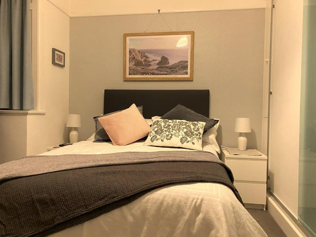 a bedroom with a bed with two pillows on it at Cliftonville, en-suite room, fridge microwave TV, great value homestay near the sea in Lymington
