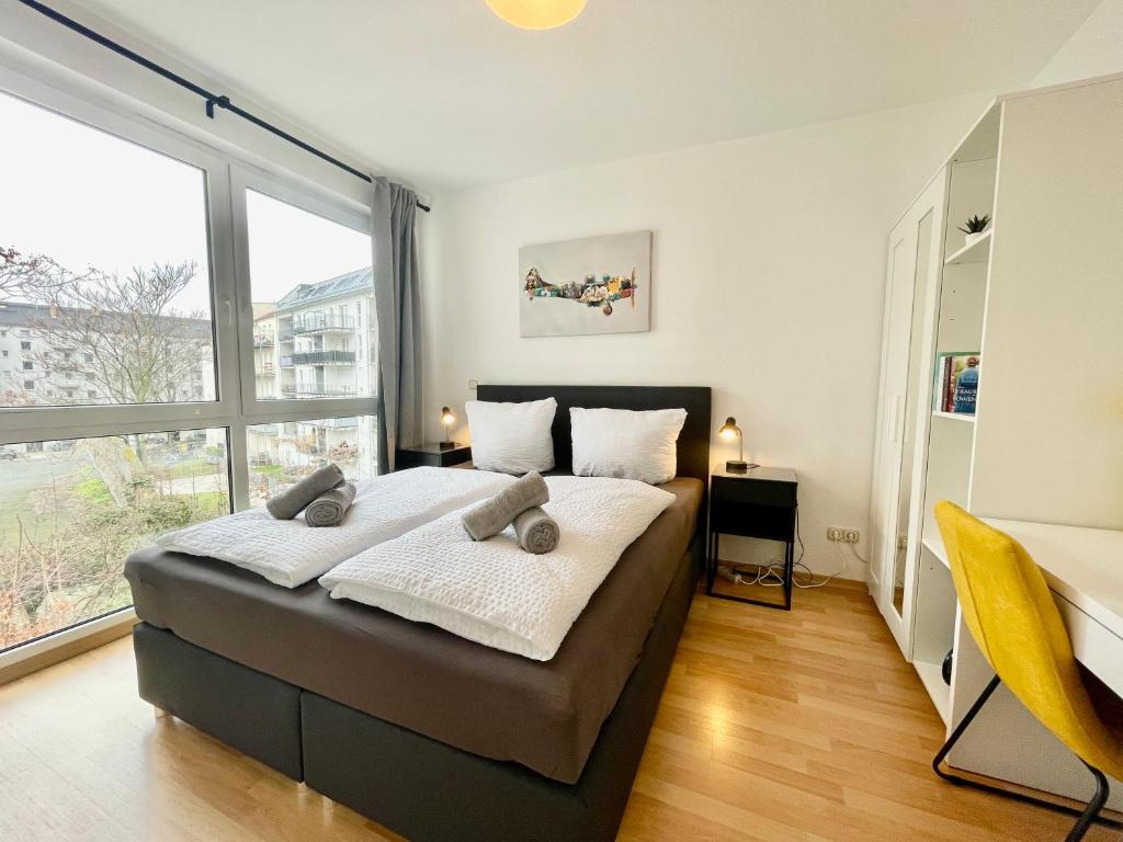 um quarto com uma cama e uma grande janela em Design City Apt Lilly - Kaffeebar, Balkon, Zentral em Leipzig