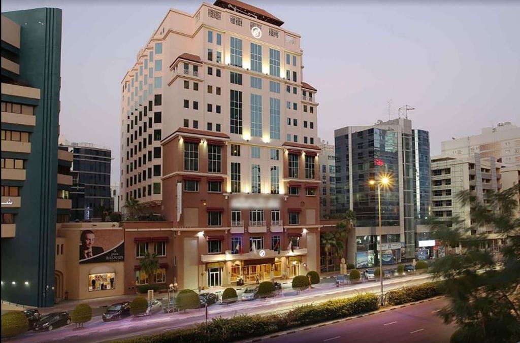 a tall building in the middle of a city at Knight Castle Hotel - Formerly known as Carlton Palace Hotel in Dubai