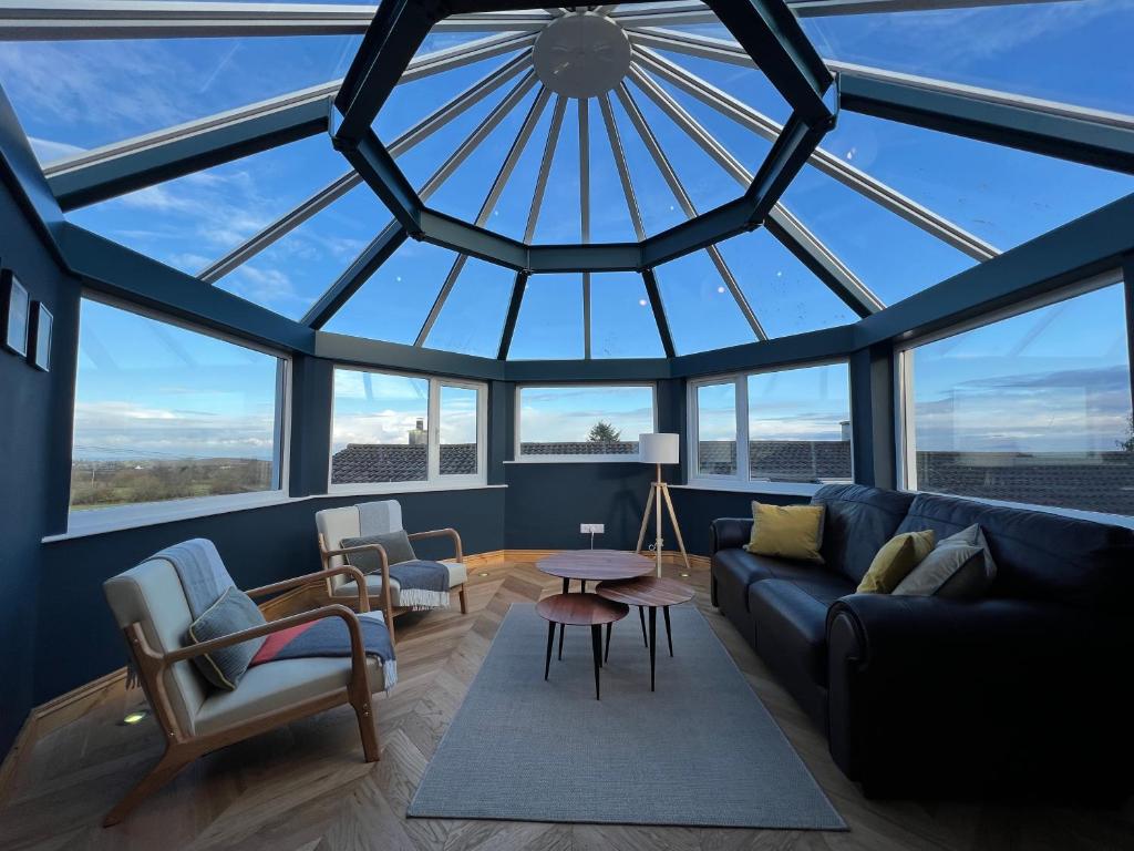 a living room with a large glass ceiling at Hunters Glebe Country Apartment in Castlerock