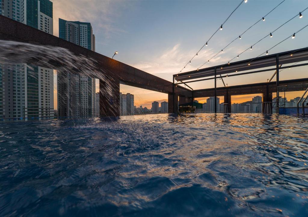 uma piscina de beiral infinito com uma ponte no meio de uma cidade em Park Marine Hotel em Incheon