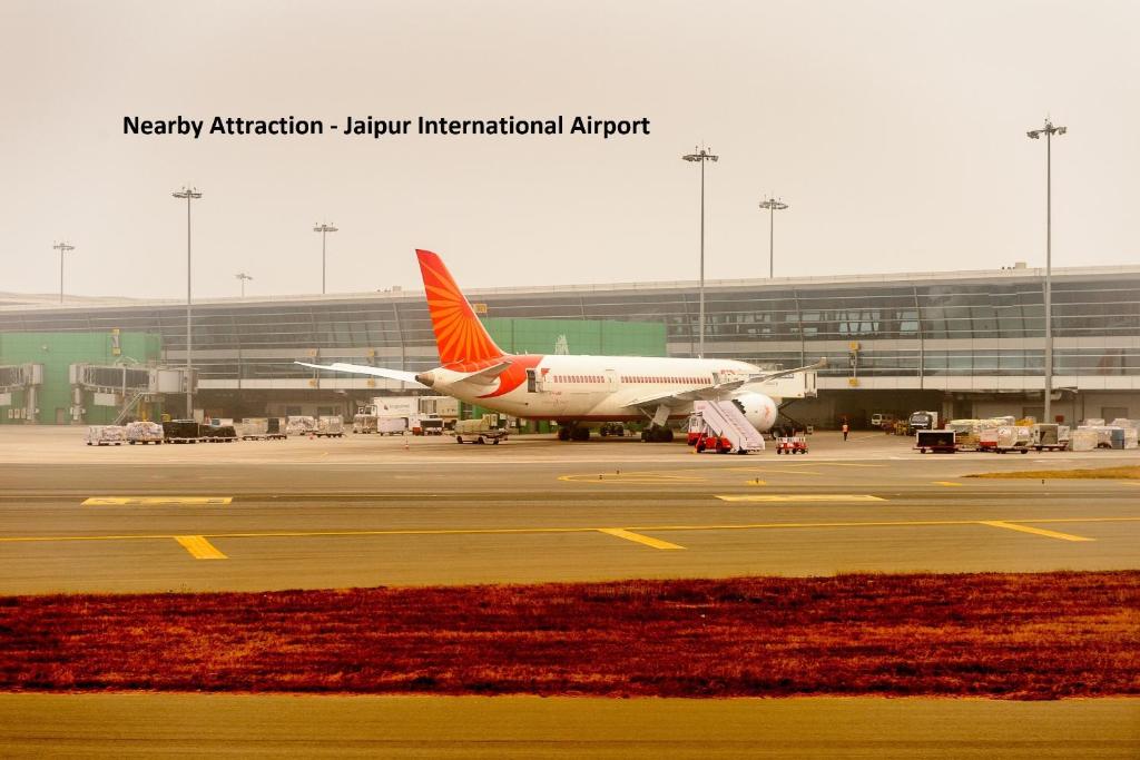 een vliegtuig is geparkeerd op de landingsbaan op een luchthaven bij OYO New Airport Residency in Jaipur