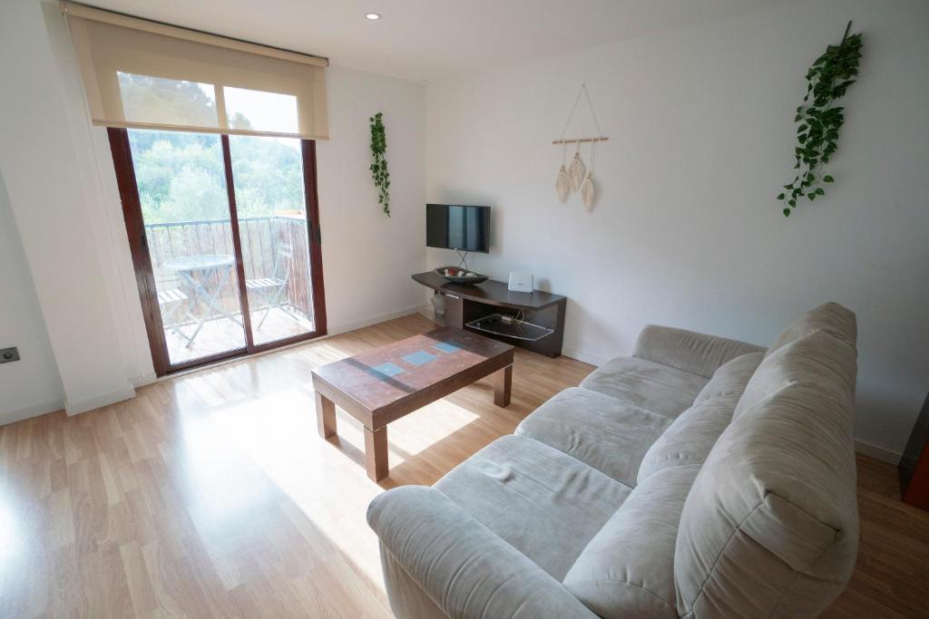 een woonkamer met een bank en een tafel bij Apartamento-Loft con vistas in Vilafames