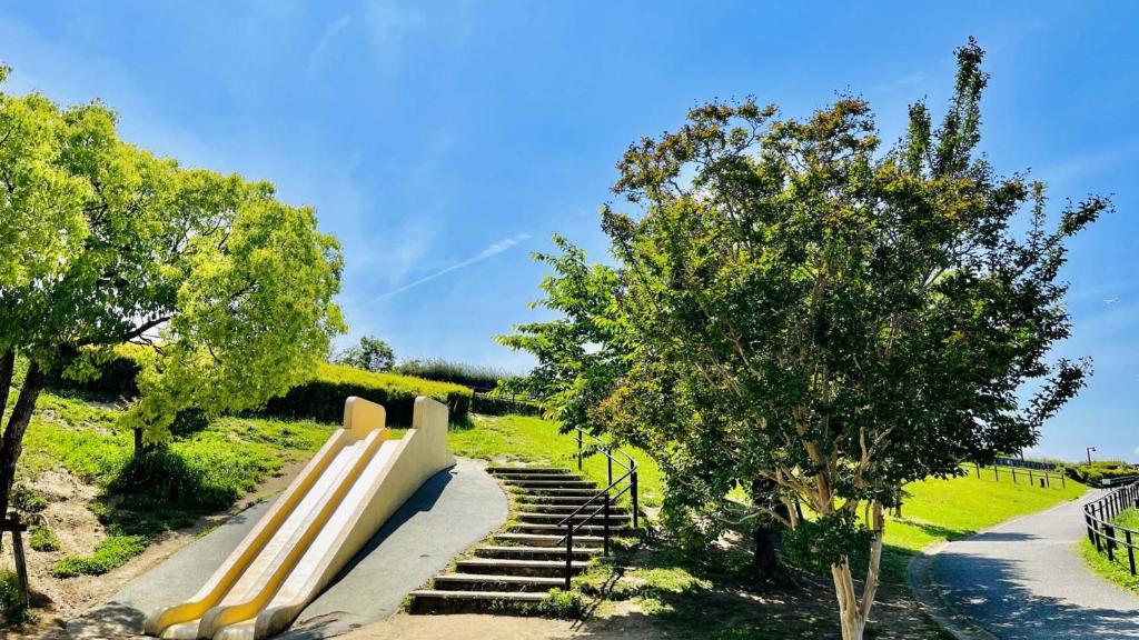 a bench in a park with stairs and trees at Toyoko Inn Osaka Itami Airport in Toyonaka