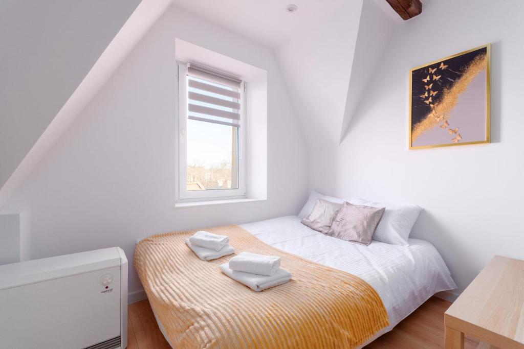 a bedroom with a bed with two towels on it at Groszowa Comfort Studio in Jelenia Góra