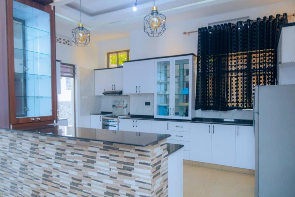 a kitchen with white cabinets and a counter top at Douglas Home in Ruhengeri