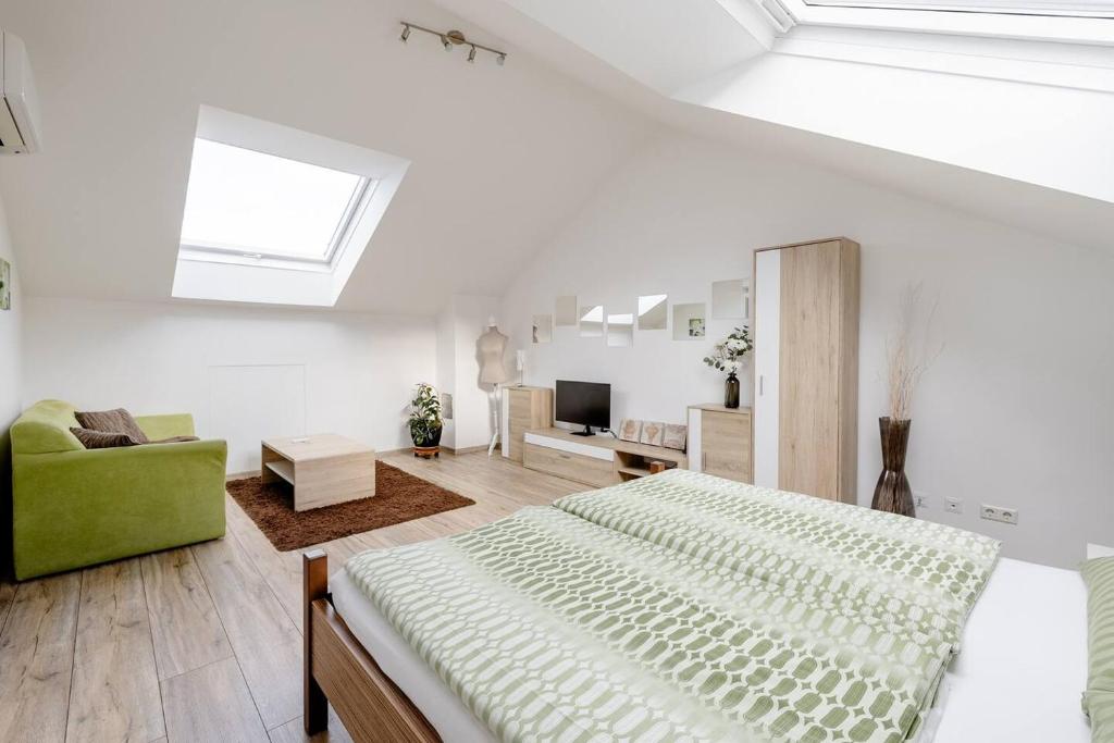 een witte slaapkamer met een bed en een groene stoel bij Gemütliches Apartment Top 5 in Wenen