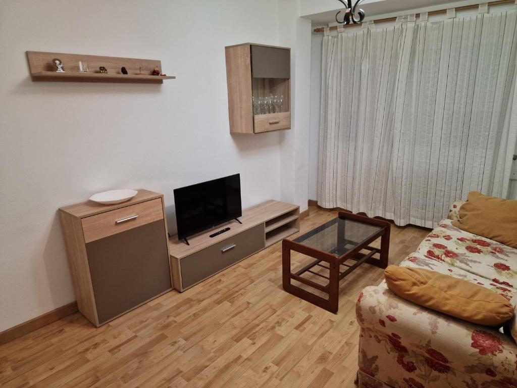 sala de estar con sofá y TV de pantalla plana en 168A Apartamento en el Natahoyo , Gijón en Gijón
