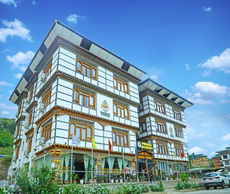 duży budynek z pomarańczowo-białym w obiekcie Punakha Residency w mieście Punakʽa